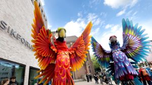 Zwei Papagei-Statuen stehen für die Eröffnungsparade des Figurentheaterfestivals Fidena in Bochum auf der Straße. Mit übergroßen Insekten und seltsamen Lebewesen wurde ein Statement gegen das Artensterben gesetzt. Foto: Dieter Menne/dpa